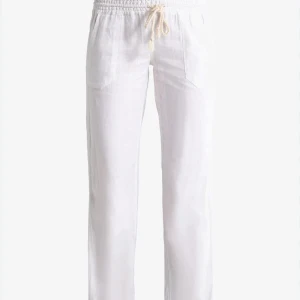 Roxy linnebyxor  - Säljer ett par vita linnebyxor från Roxy med avslappnad passform och dragsko i midjan. Byxorna har raka ben och två fickor framtill. Perfekta för varma dagar och enkel stil.