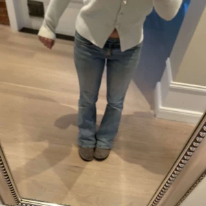 Blå lågmidjade bootcut jeans - Säljer ett par klassiska blå bootcut jeans med normal passform och låg midja. Perfekta för dig som gillar en tidlös stil med lite utsvängda ben. Storlek 32 och passar mig som vanligtvis har 36, dom har dock ett jätte litet hål mellan bena men inget som man ser så mycket eller tänker på!❤️