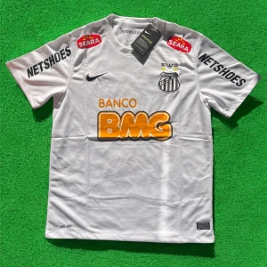 Vit Santos FC fotbollströja från Nike - Santos FC matchtröja i vitt med svarta detaljer och tryckta sponsorer som BMG, Netshoes och Seara. Klubblogga på bröstet och Nike-logga. Kortärmad modell i lätt och ventilerande material, perfekt för fotbollsträning eller match.