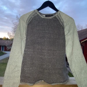 Gråmelerad stickad tröja från Jack & Jones - Säljer en gråmelerad stickad tröja från Jack & Jones. Tröjan har rund halsringning och långa ärmar i en ljusare nyans än själva kroppen. Perfekt för kyligare dagar och enkel att matcha med jeans eller chinos.