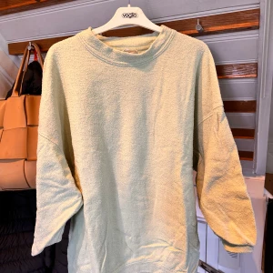 Ljusgrön frottétröja från American Vintage - Supermjuk och oversized ljusgrön tröja från American Vintage i frotté. Tröjan har rund halsringning och långa ärmar, perfekt för en avslappnad stil. Enkel design utan mönster eller detaljer.