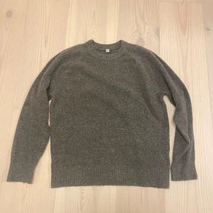 Stickad Tröja | UNIQLO. - Mysig grå stickad tröja från Uniqlo i storlek 13. Tröjan har rund halsringning och långa ärmar, perfekt för kyliga dagar. Enkel och stilren design som passar till det mesta.