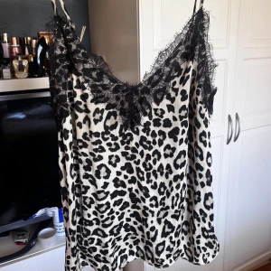 Leopardmönstrad linnetopp med spets från H&M - Säljer en snygg linnetopp från H&M med leopardmönster i svart och vit. 