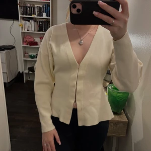 Vit kofta med v-ringning - Säljer en  super fin vit  kofta med v-ringning. Koftan har långa ärmar och en enkel design som passar perfekt till olika tillfällen. Perfekt för lager-på-lager under kyligare dagar.