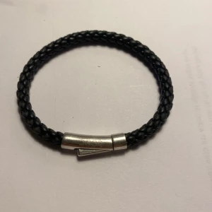 Svart flätat armband med silverlås - Snyggt svart flätat armband med ett silverfärgat lås. 