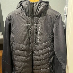 Svart jacka från Sail Racing - Säljer en svart jacka från Sail Racing med dragkedja och vuva. Jackan har en stilren design med Sail Racing-logga på bröstet. Perfekt för kyligare dagar med sin quiltade stil och praktiska fickor. väldigt fin och inte använder så mycket toppkvalitet