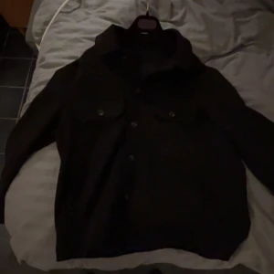 Svart overshirt med knappar- Zara  - Snygg svart overshirt med knappar framtill och två bröstfickor. Perfekt för lager-på-lager-stil. Passar bra till både vardag och mer avslappnade tillfällen. Vill få den sålt snabbt 