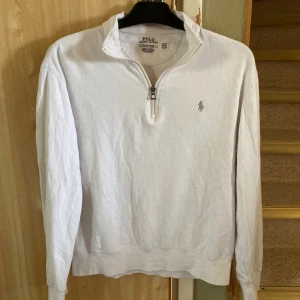 Vit långärmad tröja från Polo Ralph Lauren - Säljer en stilren vit långärmad tröja från Polo Ralph Lauren. Tröjan har en dragkedja vid halsen och det klassiska logotypbroderiet på bröstet. Perfekt för en avslappnad och snygg look. Nypris 2200kr. Jag tar emot byten och hör gärna av er vid minsta funderingar😃