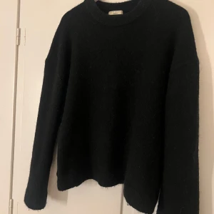 Svart stickad tröja - Säljer en stilren svart stickad tröja med rund hals och långa ärmar. Perfekt för kyliga dagar och enkel att matcha med olika outfits. Ett måste i garderoben för den som gillar klassiska plagg. Använd endast ett fåtal gånger så väldigt fint skick!! 