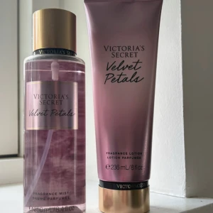 Victoria's Secret Velvet Petals set - Säljer ett set med Victoria's Secret Velvet Petals, inklusive en doftmist och en doftlotion. Flaskan är genomskinlig med guldlock och rosa etikett, medan lotionen kommer i en rosa tub med gulddetaljer. Perfekt för att dofta fantastiskt hela dagen!