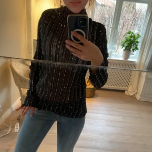 Glittrig Topp - Svart - GLITTRIG SPETS TOPP  Snygg svart spets topp med glittriga stjärnor, ränder och hög krage. Perfekt för en kväll ute eller en festlig tillställning. Den har ett stretchigt material så den blir figursydd 💞  STORLEK - M/L PRIS går att diskutera   Skriv om du har frågor 🫶