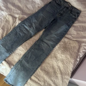 Blå jeans från Gina Tricot - Säljer ett par Bootcut jenas med slits i benen från Gina Tricot 