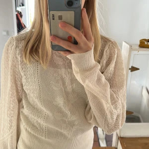 Vit spetsmönstrad tröja från Zara - Säljer en elegant vit tröja från Zara med vackert spetsmönster och långärmad design. Tröjan har en ribbad nederkant och en fin detalj med knäppning. Storlek M men liten i storleken, mer S. Oanvänd.🩷