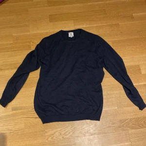 Mörkblå tröja från Urban Pioneers - Säljer en stilren mörkblå tröja från Urban Pioneers. Tröjan har en klassisk design med rund hals och långa ärmar. Perfekt för en avslappnad och snygg look.