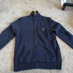 Mörkblå kofta från Ralph Lauren - Säljer min Ralph lauren fullzip för att den är för liten, 10/10 skick inga defekter. Pris kan diskuteras, hör av dig om du har frågor