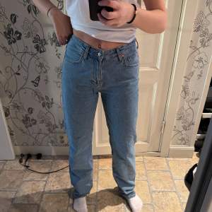 Ljusblåa jeans mid waist 28/34 från bikbok