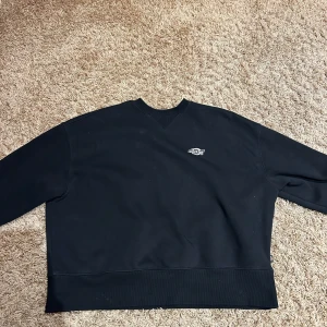 Svart tröja från Dickies - Säljer en svart tröja från Dickies i storlek XS. Tröjan har en liten logotyp på bröstet och är tillverkad i ett mjukt material. Perfekt för en avslappnad stil.