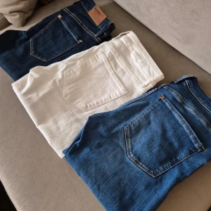 Tre par jeans - Säljer tre par jeans i olika färger. Två par är blåa och ett par är vita. De blåa jeansen har en klassisk femficksdesign och är i en mörkare tvätt. De vita jeansen är stilrena och passar perfekt för en fräsch look. Alla jeansen har knapp och dragkedja framtill. W 27" med stretch, nypris 399:- STYCK 