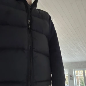 Marinblå väst från Polo Ralph Lauren - Säljer en marinblå dunväst från Polo Ralph Lauren med dragkedja och broderad logga. Perfekt för kyliga dagar och ger en stilren look. Ny pris 2100 mitt pris 1100. Det finns inga defekter på varan. Passar xs, s.