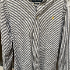 Randig skjorta från Ralph Lauren - Säljer en stilren randig skjorta från Ralph Lauren i blått och vitt. Skjortan har en klassisk passform med knappar framtill och en broderad logga på bröstet. Perfekt för en snygg och avslappnad stil.