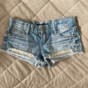 Blå jeansshorts  - Snygga blå jeansshorts från Sister med fransiga kanter och jättesnygga detaljer!! Säljer pga för små och oanvända