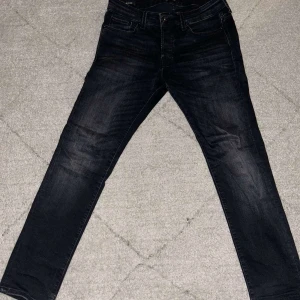 Svarta jeans från Jack & Jones- slim fit - Snygga svarta jeans från Jack & Jones i slim fit. De har en klassisk femficksdesign och är tillverkade i denim. Perfekta för en soft outfit. Storlek: 30/30
