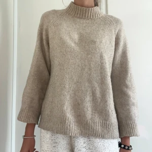 Beige stickad tröja från Zara - Säljer en beige stickad tröja från Zara med hög ribbad krage och långa ärmar. Tröjan har en loose passform och är tillverkad i mjukt material som passar perfekt för kyliga dagar. Enkel och stilren design som är lätt att matcha med jeans eller kjol. Står 152 men passar mig med xs/s ❣️finns en liten fläck som man inte lägger märke till🥹😇❣️