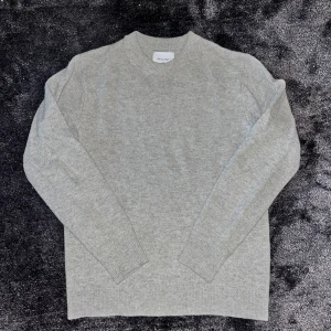 Ljusgrå merinoull tröja från Valient - Tröjan är XS men passar mer som en S.                                Säljer en stilren ljusgrå stickad tröja från Valient. Tröjan har rund hals, ribbade muddar och lång ärm. Perfekt för dig som gillar enkel och clean look. Materialet är mjukt och skönt, passar till jeans eller chinos. Fråga gärna om fler bilder eller info!