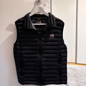 Svart dunväst från Colmar - Snygg svart dunväst från Colmar. Mycket bra skick! Säljer eftersom den börjar bli lite för liten för mig! Storlek 48 (S). Hör gärna av er vid frågor! Ny pris 2500kr nu endast 1000kr