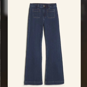 Blå bootcut jeans med fickor fram - Snygga blå jeans med bootcut-modell och två stora fickor framtill. Klassisk denimlook med raka ben som blir vidare nedtill. Storleken är 24/32