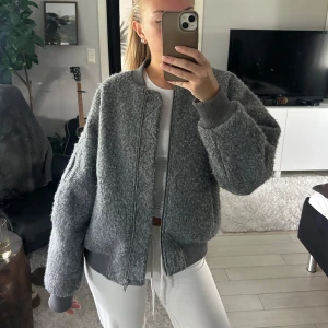 Grå teddy bomberjacka - Säljer en grå teddy bomberjacka från H&M, perfekt nu till hösten! Har använts några gånger så ändå ganska bra skick💕Säljer för 200kr