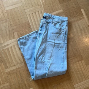 Ljusblå jeans Strlk XL - Säljer ett par ljusblå jeans med rak passform och klassisk femficksdesign. Jeansen har normal midja och är tillverkade i mjukt denimtyg. Perfekta för dig som gillar en enkel och tidlös stil. Passar till sneakers eller boots. Jeansen är street/skate stil med en relaxed passform. Köpta från Junkyard för ca 1 år sedan och sparsamt använda. Fläckar på byxorna (se bild 4&5). Mått: Längd (Midja-fot) 114cm. Midje mått:52cm. Bredd ben: ca 30cm. Längd ben ca 80cm