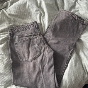 Grå jeans från Zara, raka ben - Säljer ett par grå jeans från Zara med raka ben och klassisk femficksdesign. Jeansen har normal midja och är tillverkade i ett mjukt bomullsmaterial med lite stretch. Perfekta för en chill och stilren look.