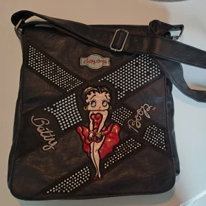 Betty boop - Säljer min Betty boop väska. Den är använd men i bra skick och I äkta läder. Köpte den för ett år sedan men originala designen är från tidigt 2000-tal. ‼️ Skriv om du har frågor ‼️