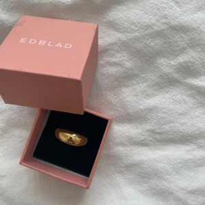 Guldfärgad ring från Edblad - Snygg och chunky guldfärgad ring från Edblad med blank yta. Ringen har en rundad, bred form. Levereras i original ask.