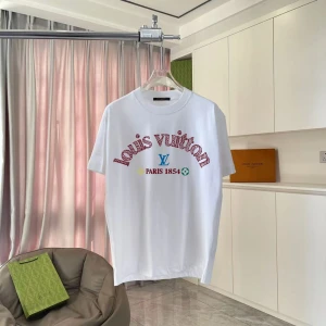 Vit Louis Vuitton t-shirt med tryck - Snygg vit t-shirt från Louis Vuitton med färgglatt tryck på bröstet där det står 'Louis Vuitton Paris 1854'. Klassisk rund hals och korta ärmar. Mjuk bomullskvalitet och en liten patch med logga på ryggen. Perfekt för dig som gillar exklusiva streetwear-vibbar.