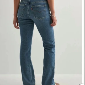 Levi's blå bootcut jeans - Säljer ett par Levi's jeans i modell superlow boot i mellanblå tvätt. Jeansen har bootcut passform och är i storlek 25/30, köpta för 950 och har används fåtal gånger 