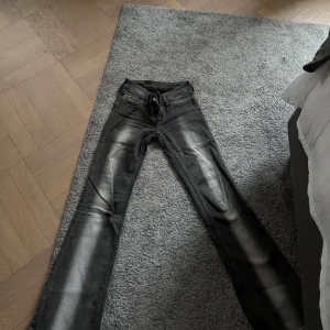 Grå bootcut jeans - Säljer ett par grå jeans med tvättade detaljer längs benen.