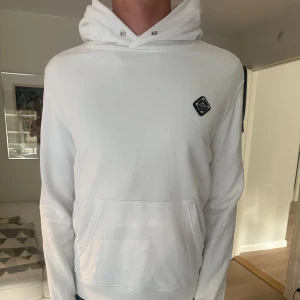 J.Linderberg Vit hoodie  - Vit hoodie från J.Lindeberg. Använd fåtal gånger, storleken är M som passar M. Tog av snöre för tyckte det var snyggare utan, men tappade bort det. VID SNABB AFFÄR KAN PRIS DISKUTERAS🤩