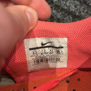 Nike Mercurial fotbollsskor röd/vit - Säljer ett par Nike Mercurial fotbollsskor i rött och vitt med svarta detaljer och stora Nike-loggor. Skorna har snörning, låg profil och dobbar för gräsplan. Snygg design med tunna vita linjer och svart sula. Perfekta för dig som vill sticka ut på planen.