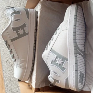 DC Shoes Court Graffik - White and Grey - Helt nya, originalförpackning och etikett finns kvar.  Obs! Har FLERA samma skor i storlek 42.5, 43 och 44. Kontakta mig för fler storlekar eller frågor!