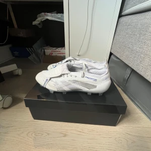 Adidas Predator fotbollsskor vita/blå - Adidas predator fotbollskor, använda 4 gånger pga för små för mig. Du får även med en bag och boxen!                                      Nytt skick💫