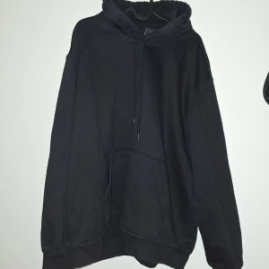 Svart hoodie från H&M, relaxed fit - En svart hoodie från H&M i relaxed fit med klassisk känguruficka och snörning i huvan. Tröjan är i storlek L och har långa ärmar. Perfekt för dig som gillar en oversized och chill stil.