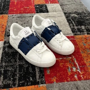 Valentino Garavani sneakers med blå detalj - ✨ Valentino Garavani Open Sneakers – Äkta & i toppskick ✨  Säljer ett par ikoniska Valentino Open sneakers – en tidlös och lyxig modell med den klassiska breda kontrastremmen.