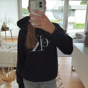 Svart Calvin Klein hoodie med logga - Svart hoodie från Calvin Klein med stor CK-logga i vitt på bröstet. Tröjan har huva, långa ärmar och en klassisk känguruficka framtill. Mjuk och skön bomullskvalitet, perfekt för chill dagar. Passar dig som gillar enkel och stilren streetwear.