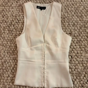 Vit satin väst från Zara  - En supersnygg vit korsetttopp från Zara, nästan aldrig använd. Materialet är i satin. Skriv för mer information🩷 kan även tänka mig byta till en i xs