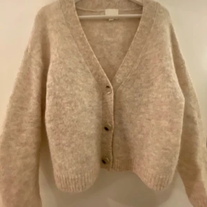 Beige kofta från H&M - Mysig beige kofta från H&M i en ull- och alpackablandning. I nyskick, passar M-L lite mindre i passformen