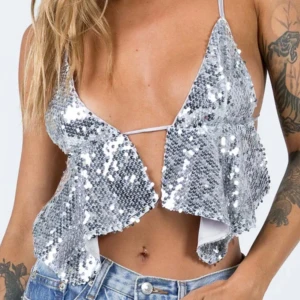 Silver paljettopp med öppen rygg - Säljer en glittrig silverfärgad paljettopp med smala axelband och öppen rygg från Princess polly. Toppen är  v-ringad  och knyts i ryggen för en justerbar passform. Jätte snygg topp!😊