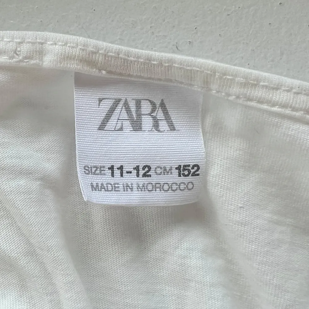 Säljer en söt vit ärmlös topp från Zara med volangdetaljer framtill. Perfekt för varma sommardagar. Toppen är tillverkad i ett lätt och luftigt material.. Yläosat.