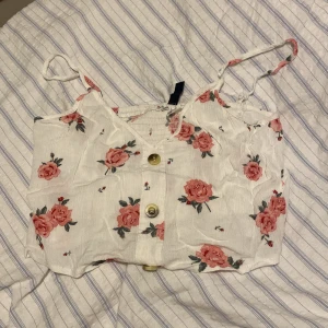 Topp - Kort topp med blommigt mönster, väldigt fin och välvårdad. 